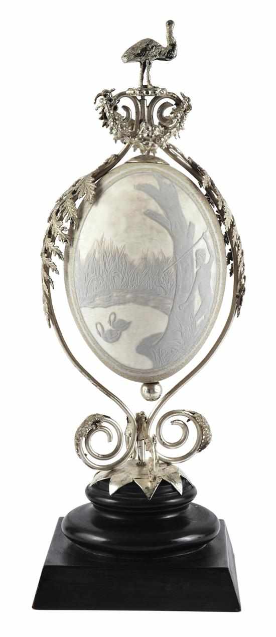 Appraisal: A WHITE METAL MOUNTED CARVED EMU EGG The egg cameo