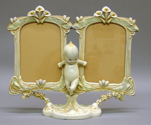 Appraisal: Kewpie metal double picture frame Ivory and pastel in color