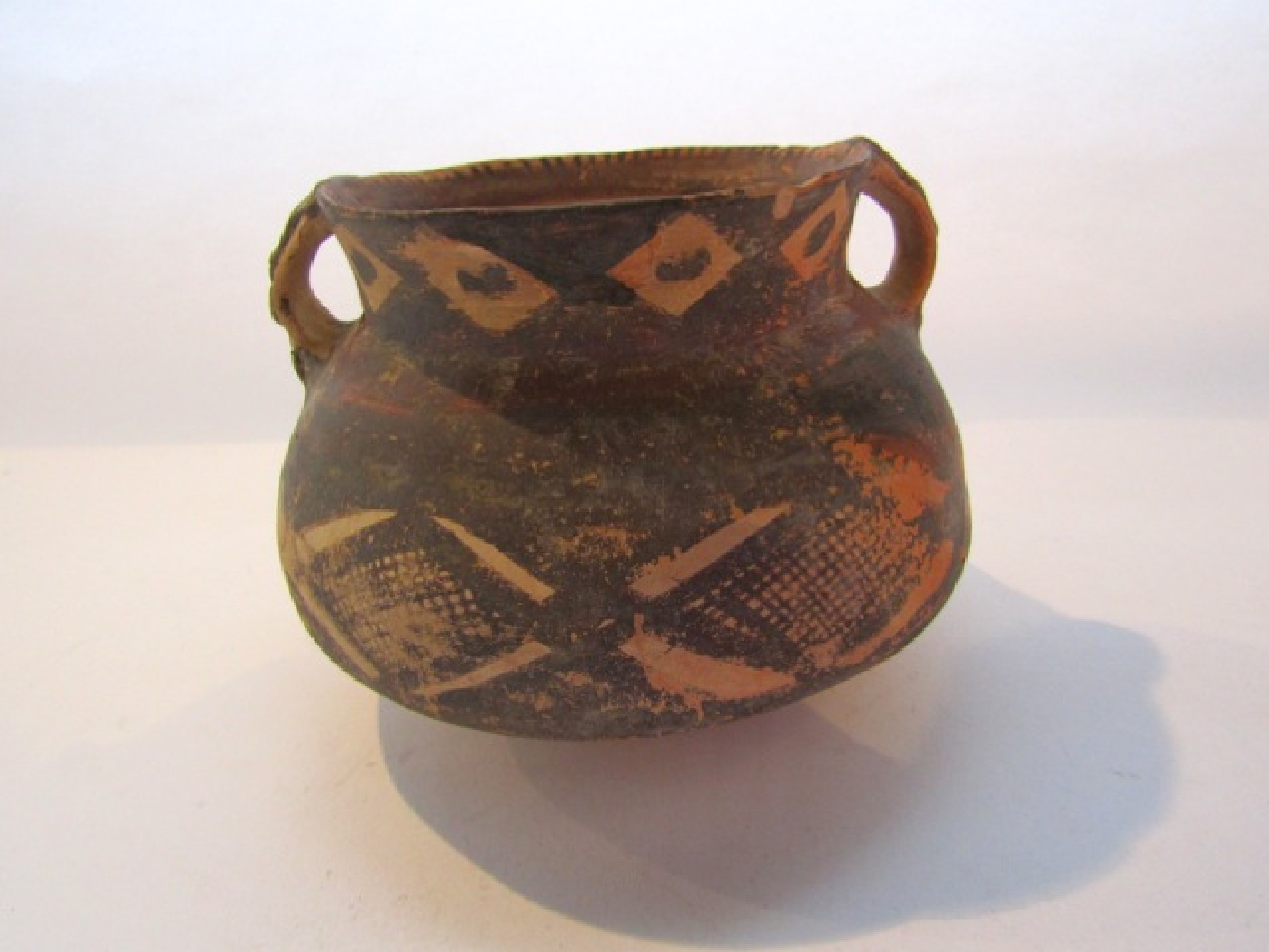 Appraisal: A two handled terracotta vessel with simple painted geometric decoration