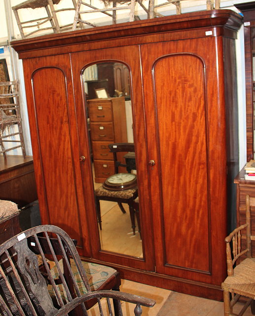 Appraisal: A VICTORIAN MAHOGANY TRIPLE WARDROBE the central mirrored door enclosing