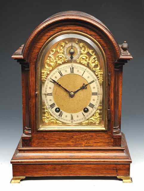 Appraisal: AN EARLY TH CENTURY OAK MANTEL CLOCK the arched brass