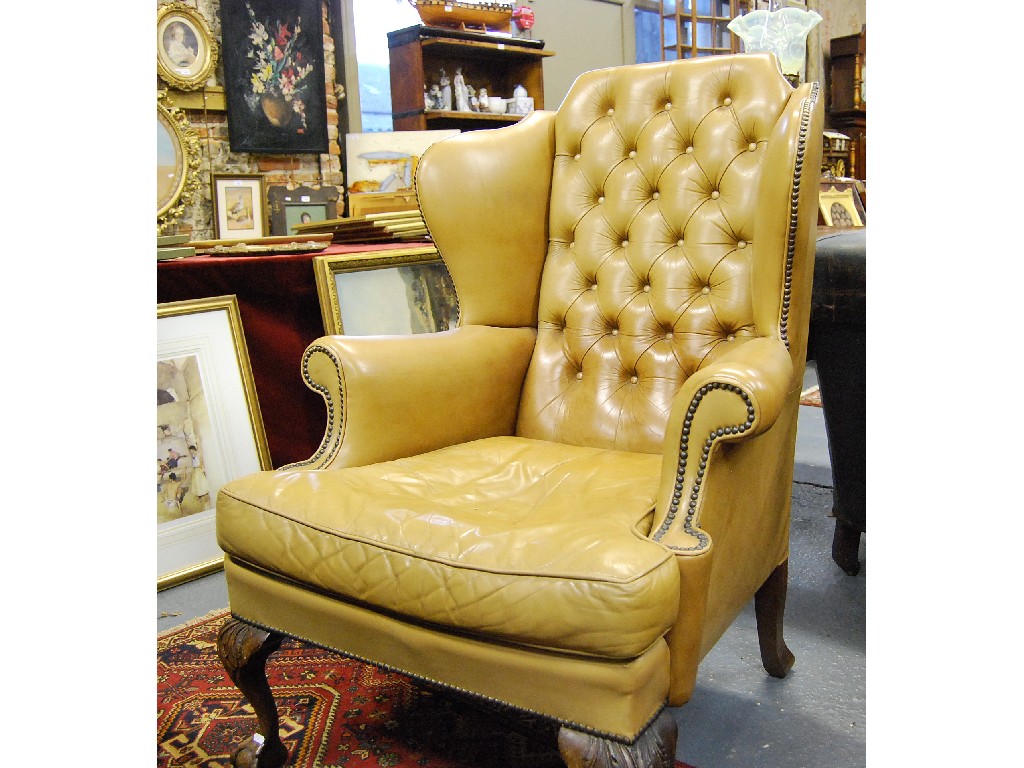 Appraisal: A Georgian style buttoned tan leather wing arm chair having