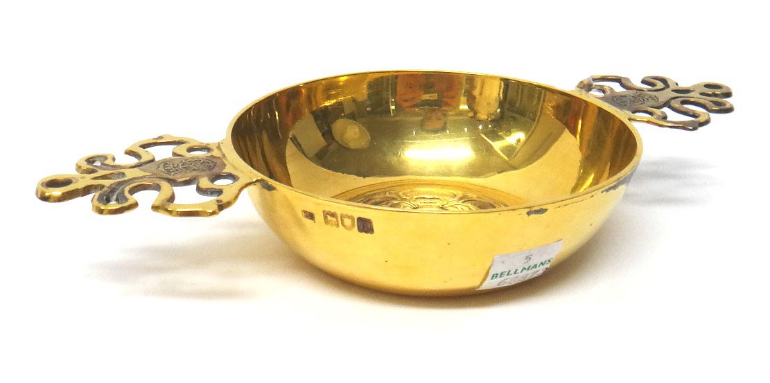 Appraisal: A silver gilt twin handled circular porringer the centre of