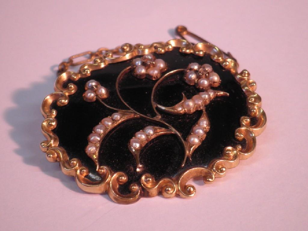 Appraisal: A Victorian black enamel brooch with applied seed pearl and