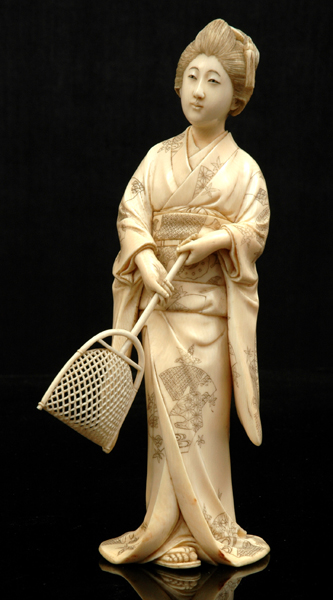 Appraisal: A JAPANESE IVORY OKIMONO OF A GIRL HOLDING A SCOOP