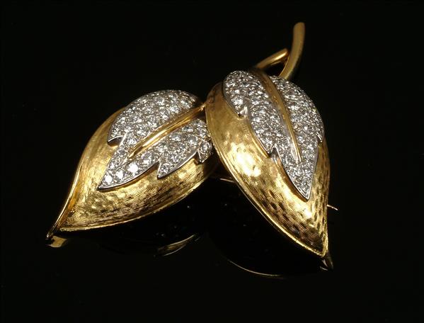 Appraisal: A diamond brooch s designed as two interlaced textured leaves