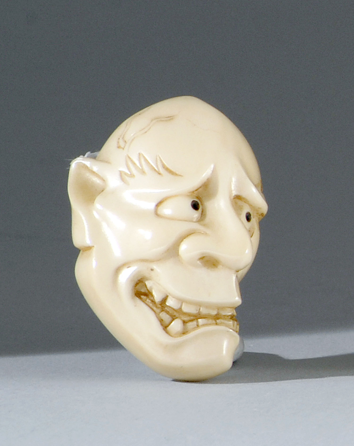 Appraisal: IVORY MASK NETSUKE Meiji PeriodDepicting Hannaya Signed Not available for