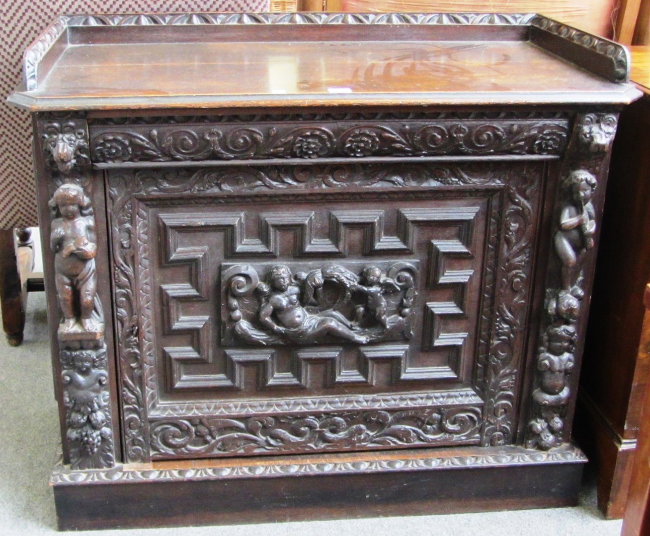 Appraisal: A Victorian carved oak side cupboard with single door on