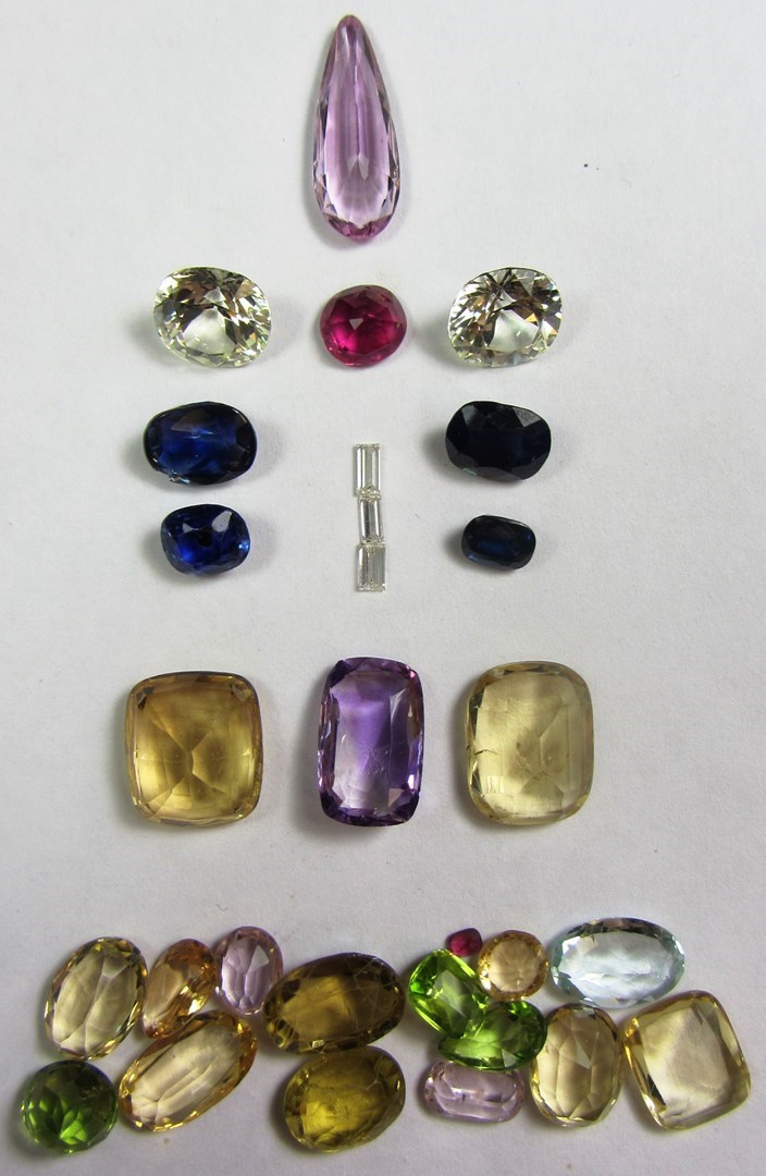 Appraisal: A collection of unmounted gemstones including small baguette diamonds sapphires