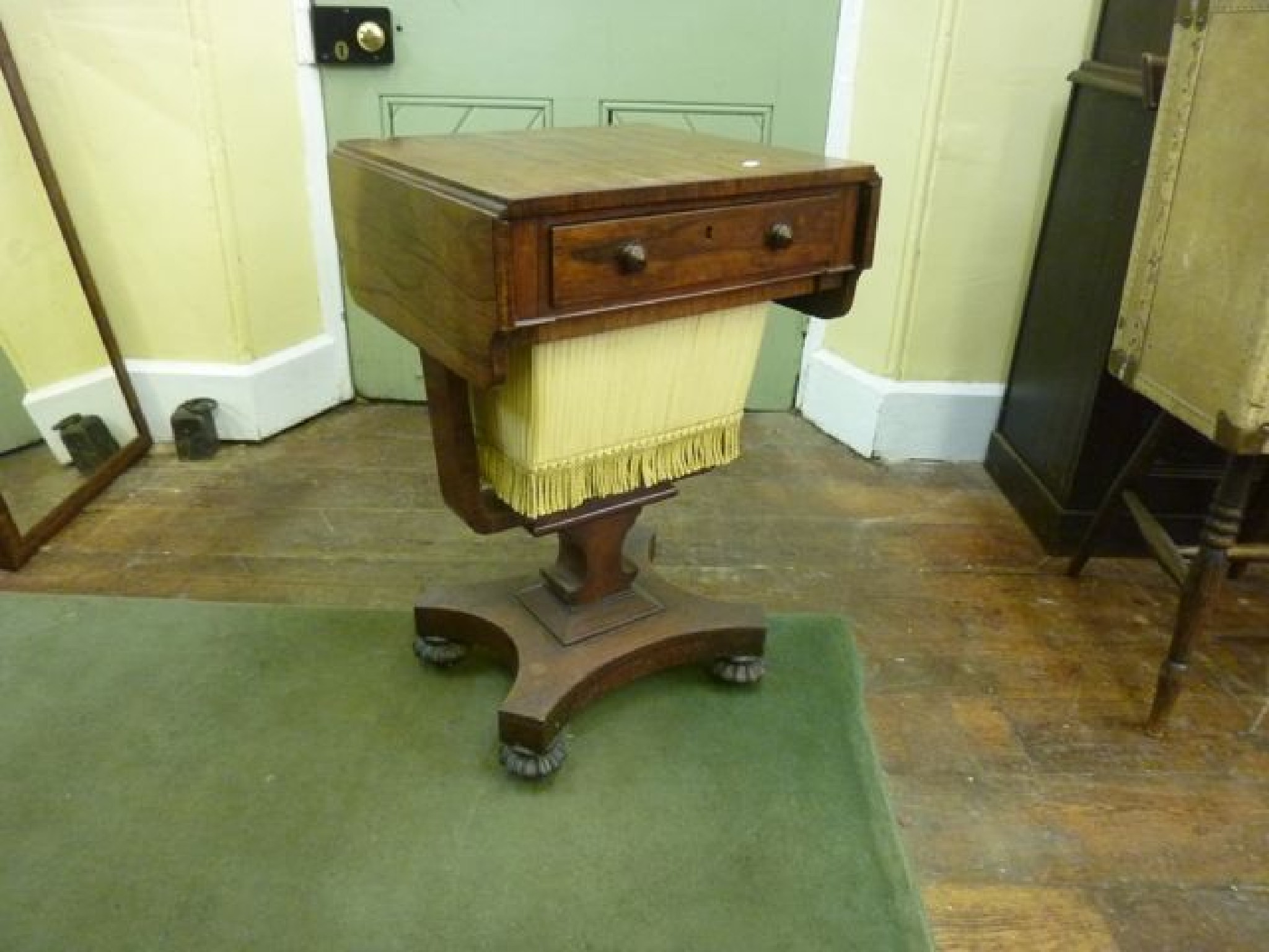 Appraisal: A Regency rosewood drop leaf sewing table with single frieze