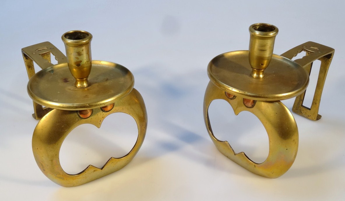 Appraisal: A pair of brass fire dog candlesticks in the manner