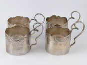 Appraisal: Four silver teaglass holders with scrolling handles and shaped chased