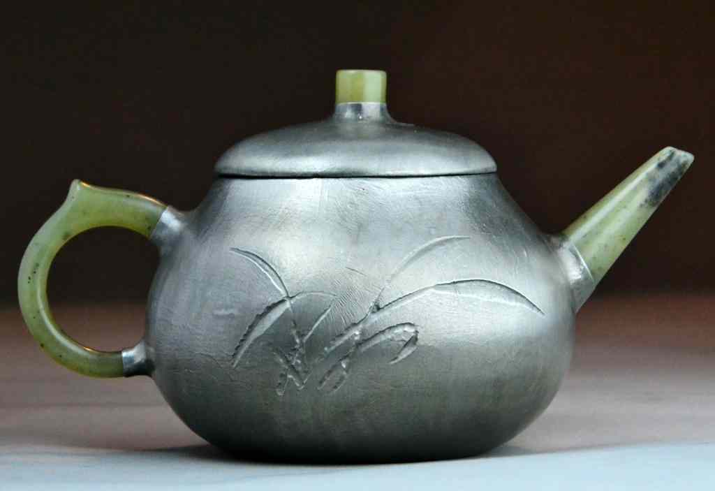 Appraisal: Chinese Pewter Jade Tea PotThe pewter tea pot finely incised