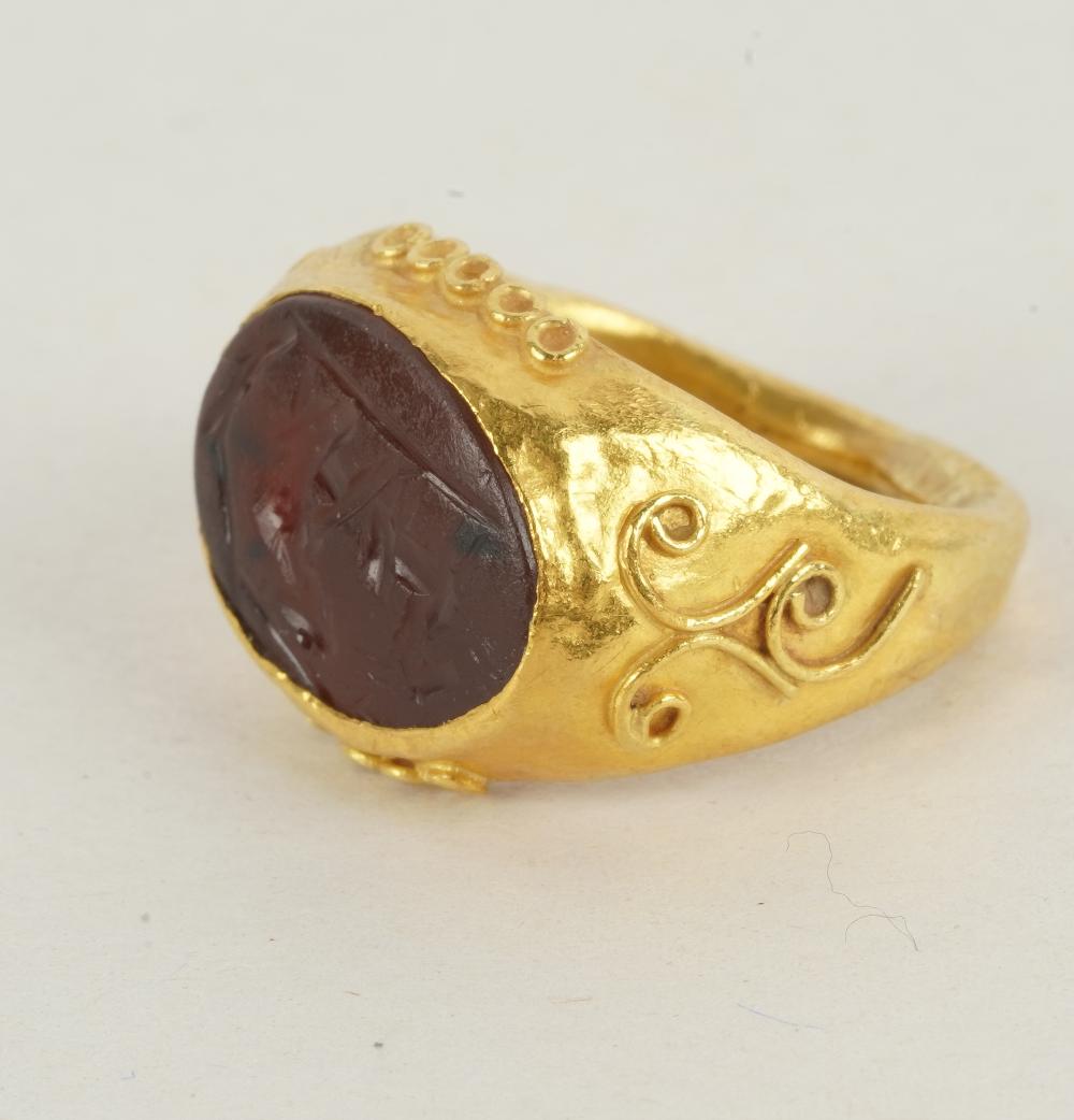 Appraisal: KARAT YELLOW GOLD SIGNET RINGcentering one carved oval brownish-red tablet-cut