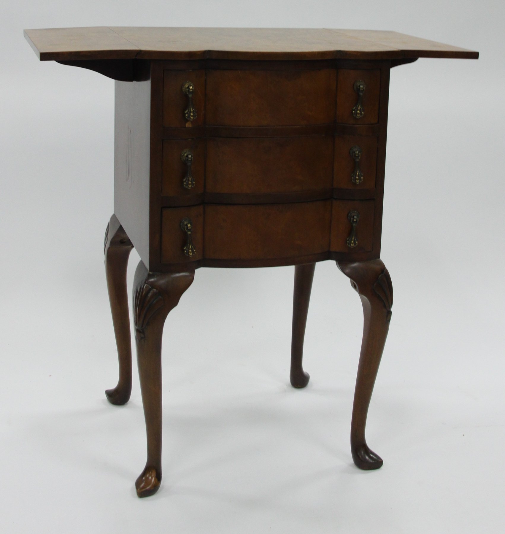 Appraisal: A figured walnut two-flap chest fitted three drawers on cabriole