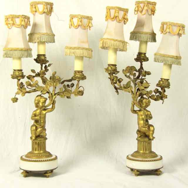 Appraisal: A pair of gilt metal and white marble candelabra modelled