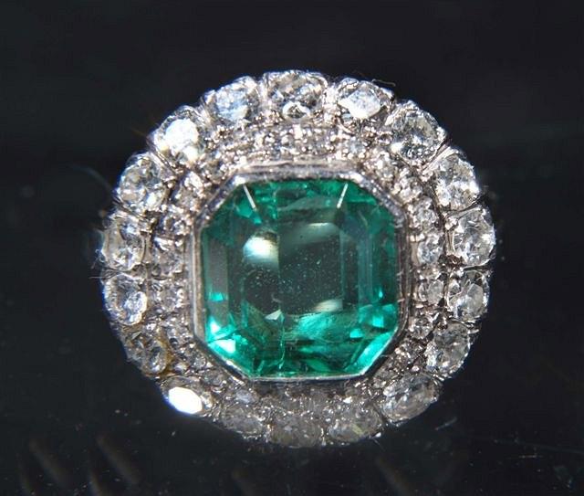 Appraisal: AN EMERALD AND DIAMOND CLUSTER RING central octagonal shaped emerald