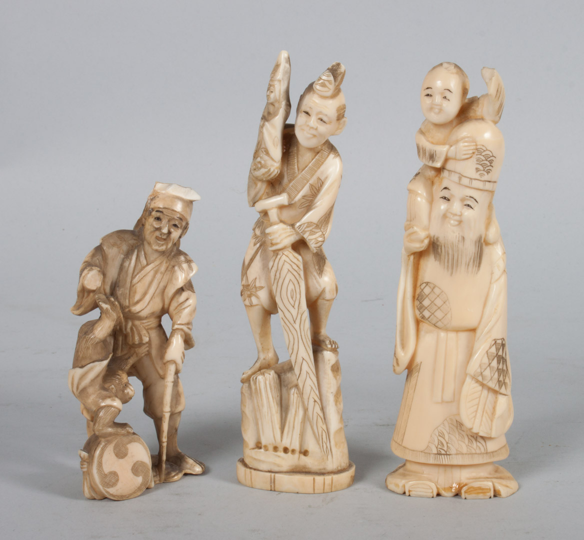 Appraisal: Three Japanese carved ivory figural groups including man with monkey