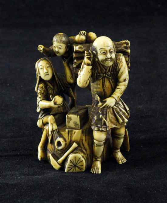 Appraisal: A Japanese stained ivory group of a woodsman and two