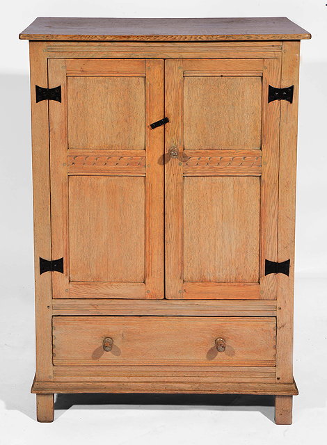 Appraisal: A LIMED OAK SIDE CABINET with twin panelled doors over