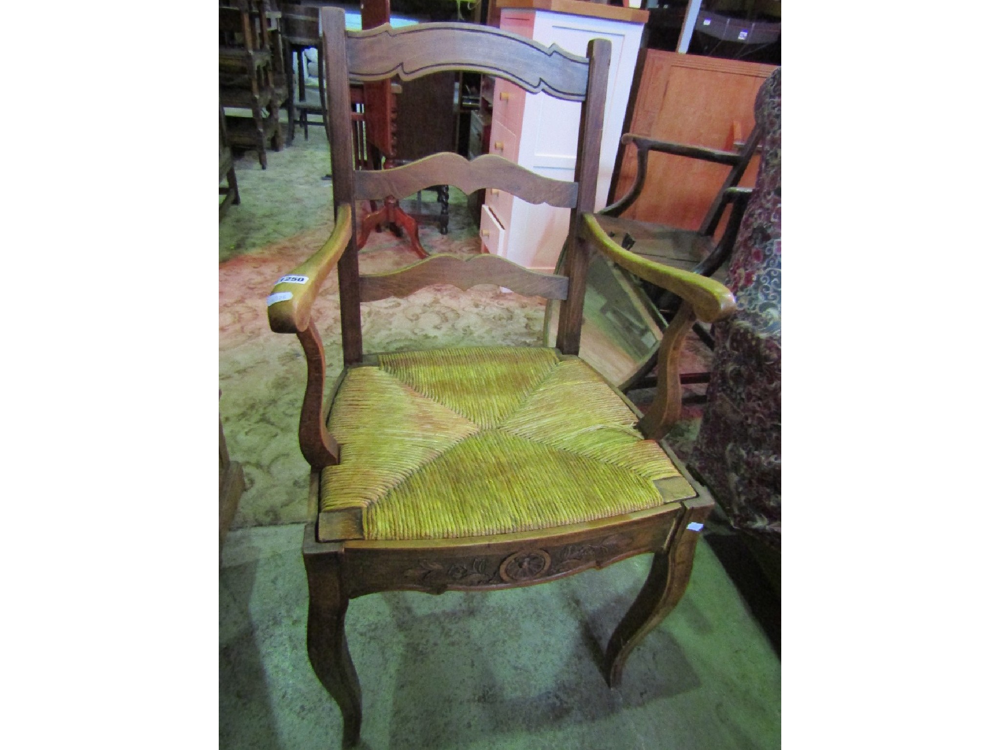 Appraisal: A continental stained beechwood open elbow chair with ladderback over