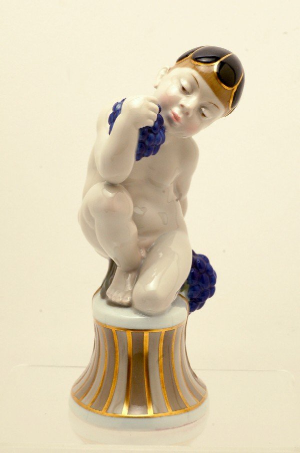 Appraisal: Porcelain figurine of kneeling nude boy holding bunches of grapes