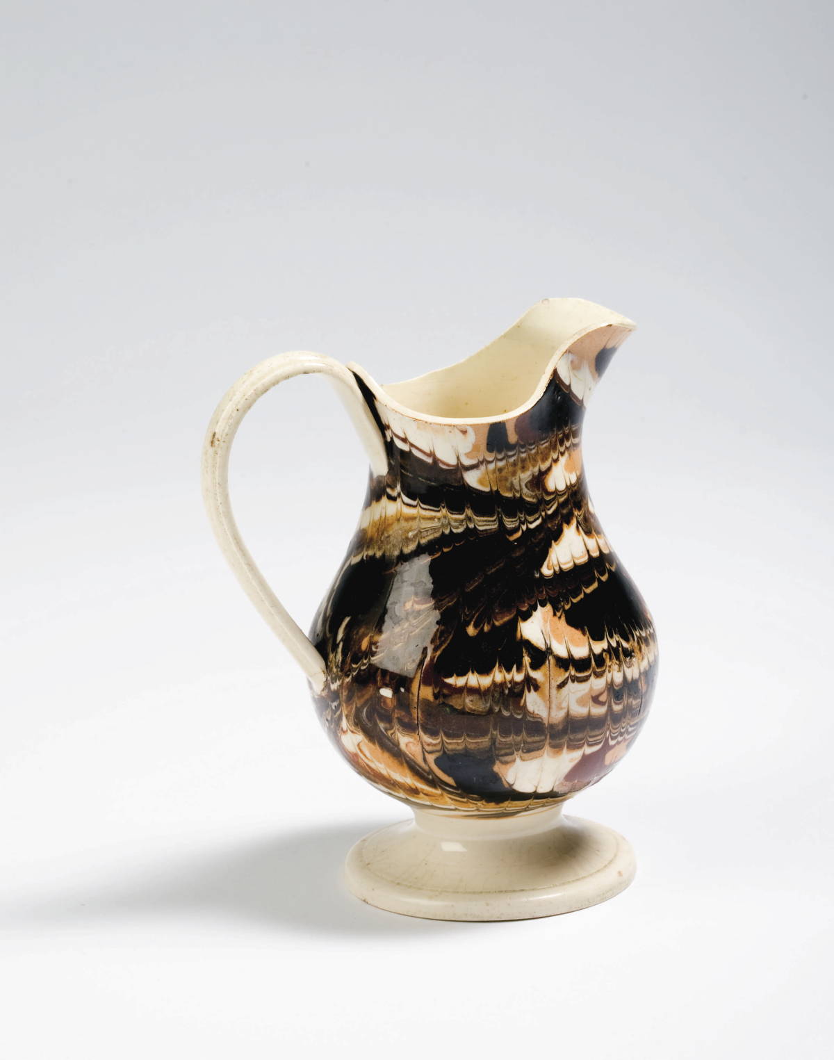 Appraisal: BRITISH CREAMWARE MOCHAWARE MILK JUG CIRCA Of baluster form slip-marbled