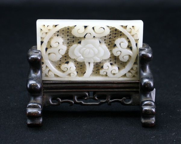 Appraisal: A white jade pierced rectangular panel with central flower surrounded