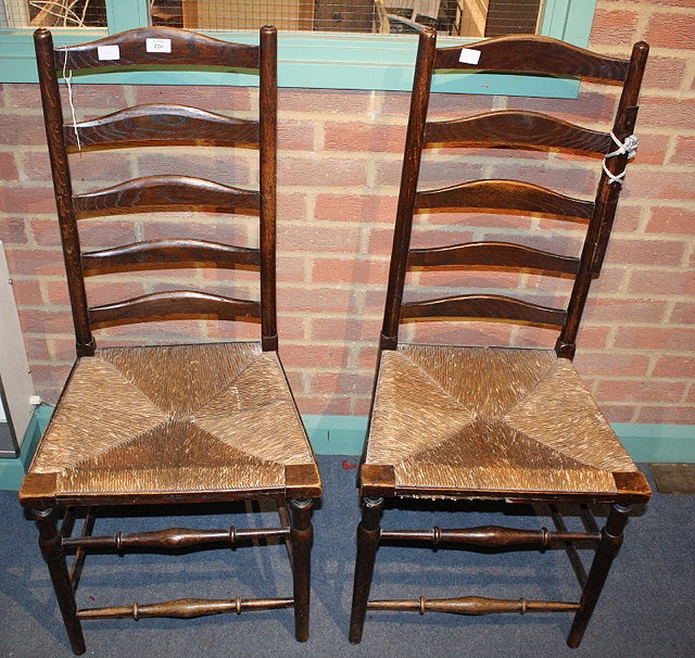 Appraisal: A PAIR OF OAK LADDER BACK CHAIRS with rush seats