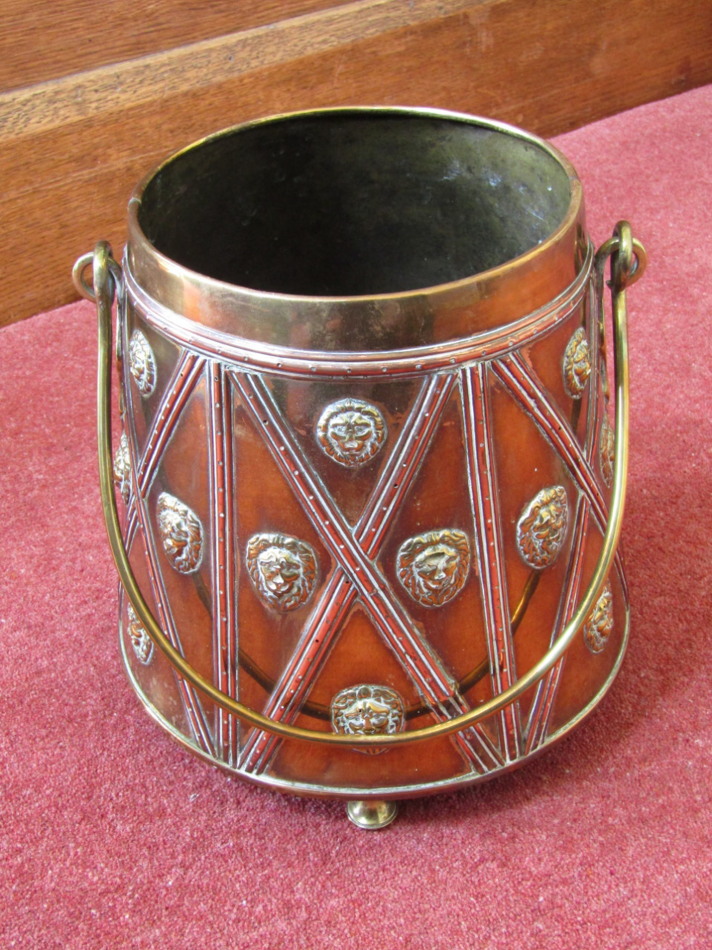 Appraisal: A Dutch embossed brass and copper coal bucket with lions