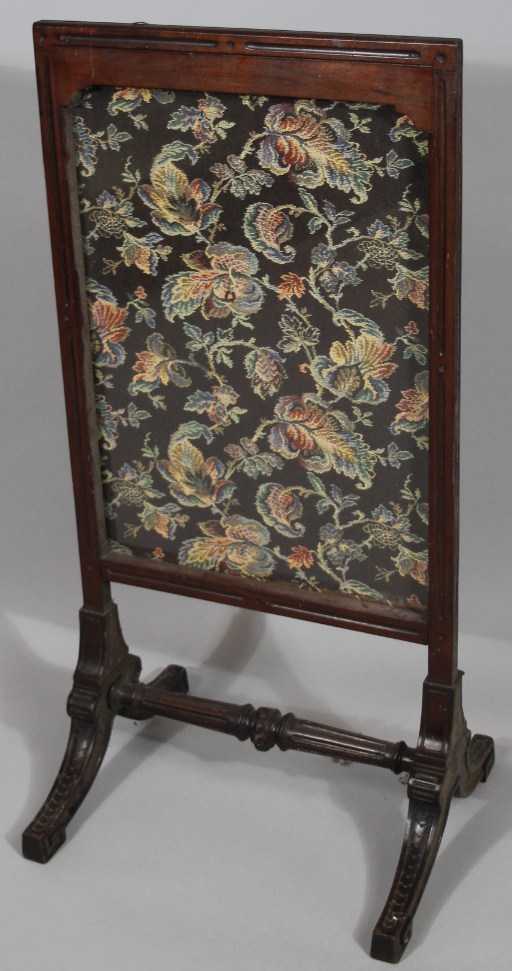 Appraisal: An Edwardian fire screen with embroidered centre on scroll supports