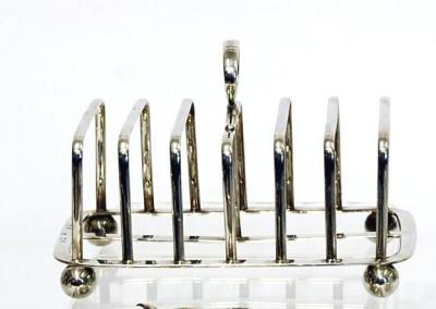 Appraisal: A GEORGIAN TOAST RACK of rounded oblong form with seven