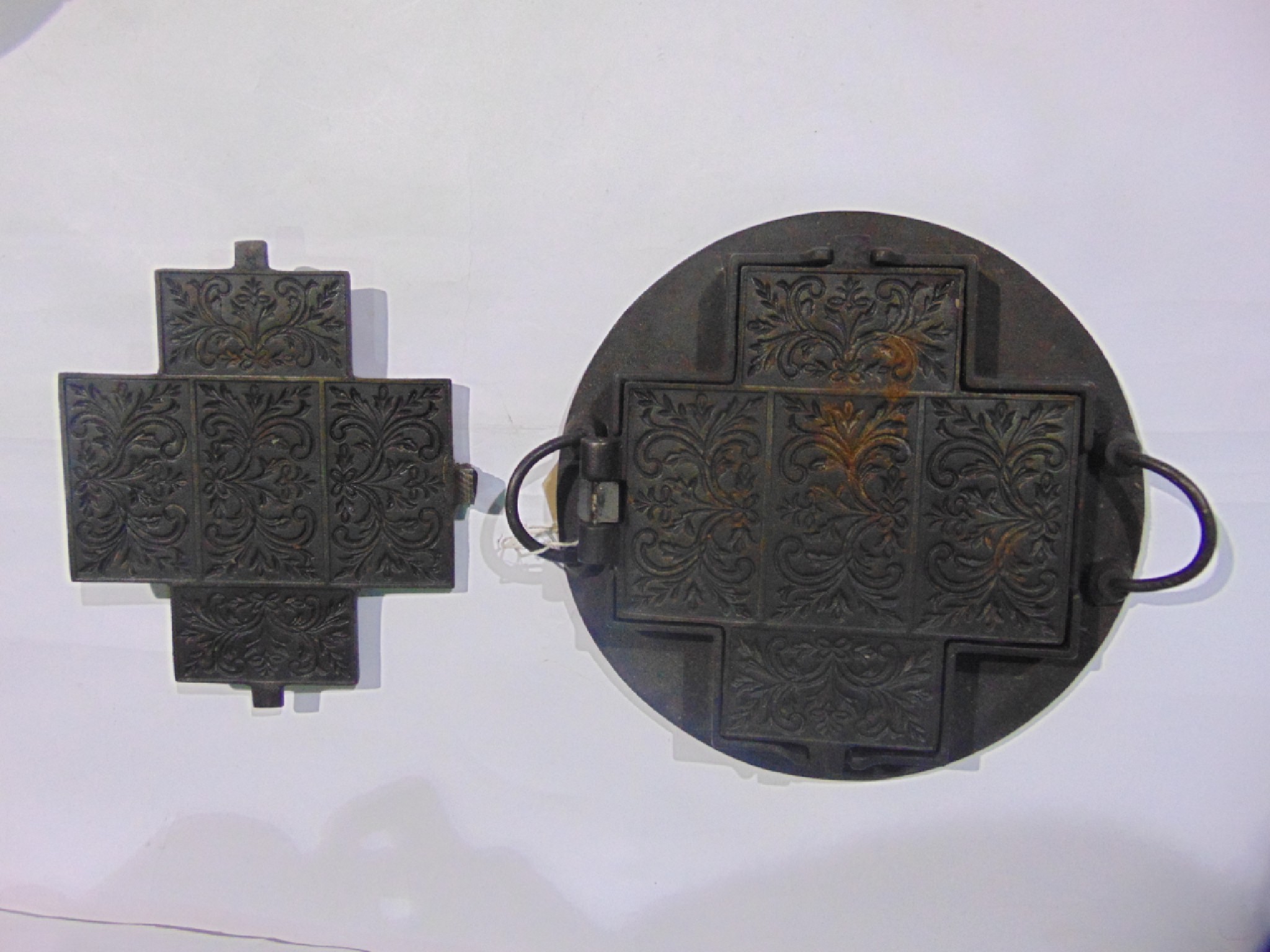 Appraisal: A heavy cast iron mould of crossed form with scrolling