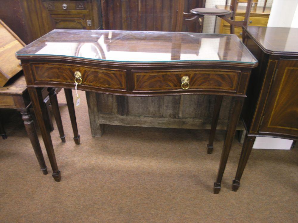 Appraisal: A reproduction mahogany serpentine fronted serving table cross-banded top above