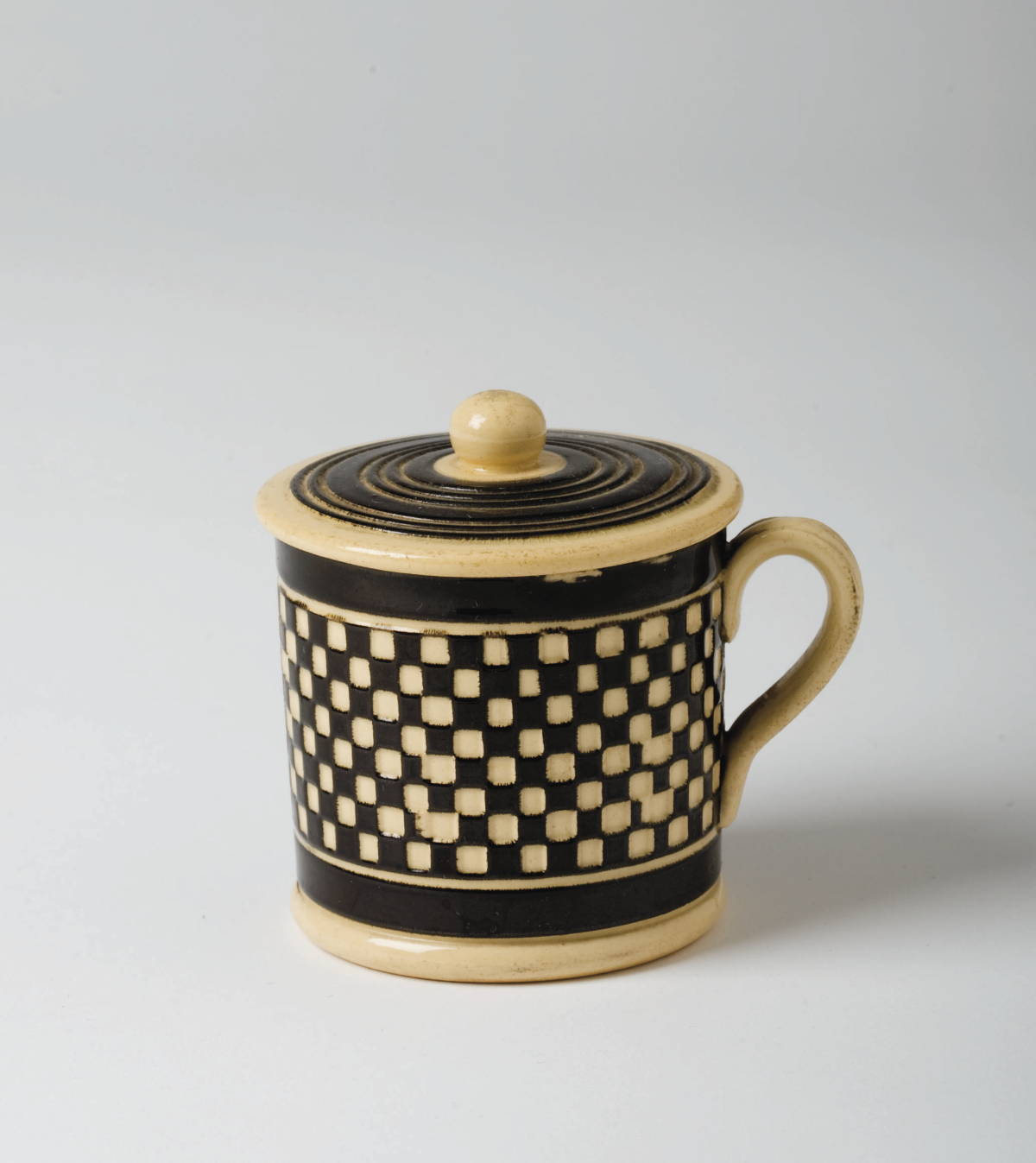 Appraisal: BRITISH CREAMWARE MOCHAWARE MUSTARD POT AND COVER CIRCA Engine-turned through