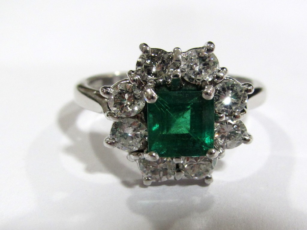 Appraisal: An eighteen carat white gold emerald and diamond cluster ring