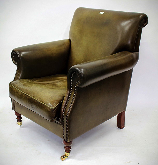 Appraisal: AN ARMCHAIR with green leather upholstery on turned front legs