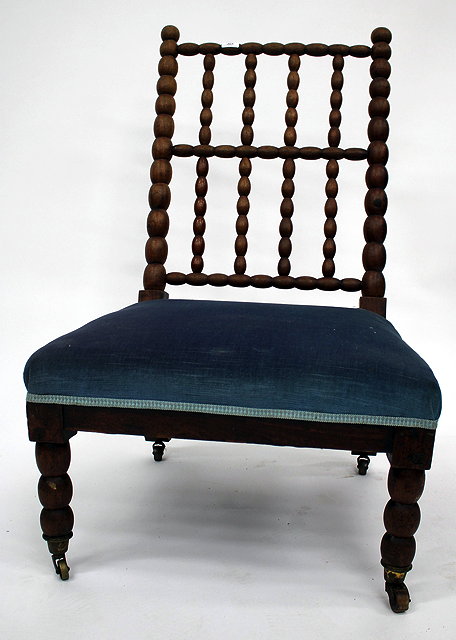 Appraisal: A LATE TH CENTURY BOBBIN BACKED CHAIR with broad overstuffed