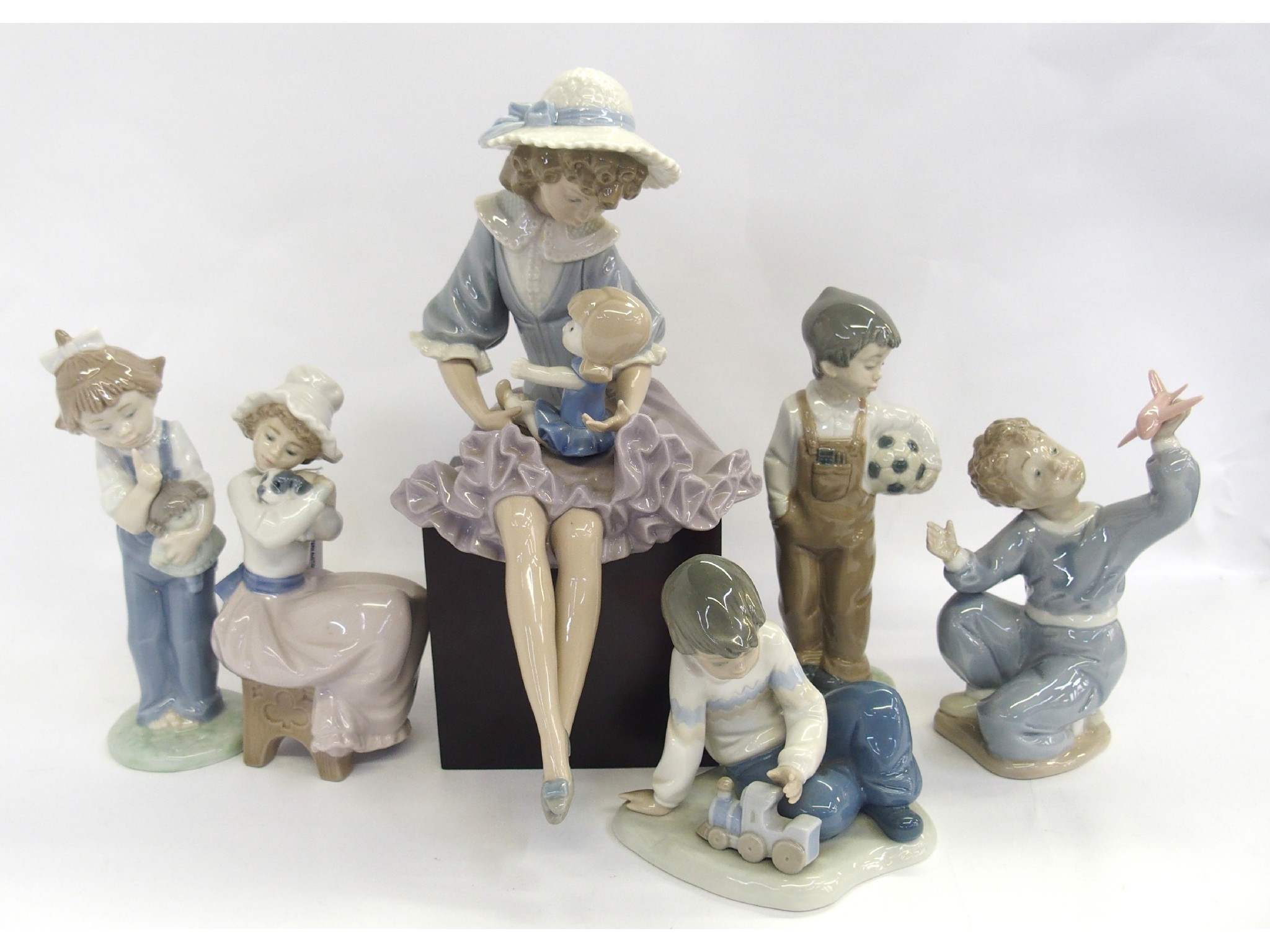 Appraisal: Five Nao figures and a Lladro figural group on wood