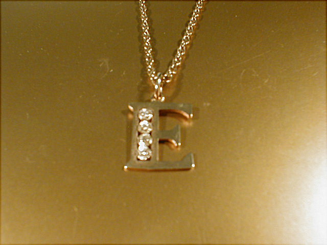 Appraisal: A ct gold necklace with 'E' pendant set with diamond