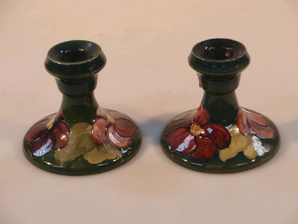 Appraisal: A pair of Moorcroft dwarf candlesticks with flower decoration on