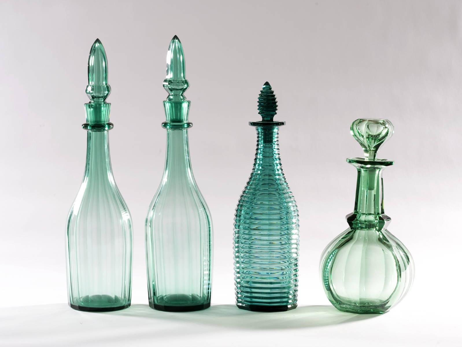 Appraisal: PAIR OF PANELLED GREEN GLASS BAR BOTTLES AND TWO GREEN