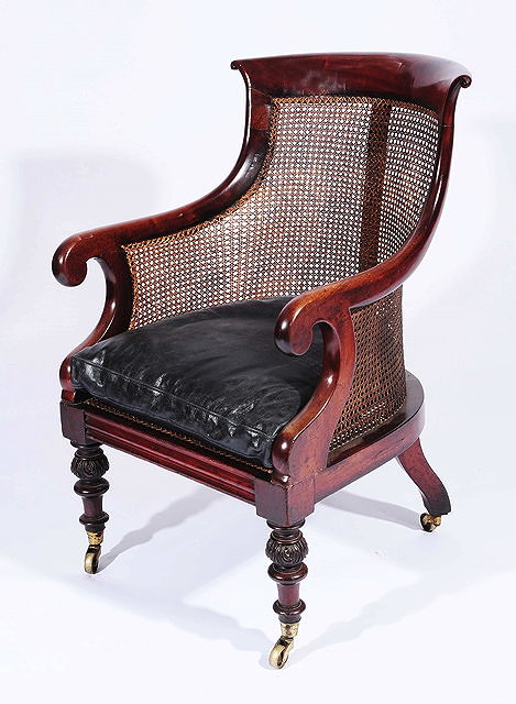 Appraisal: A George IV mahogany Bergere library chairwith cane back scroll