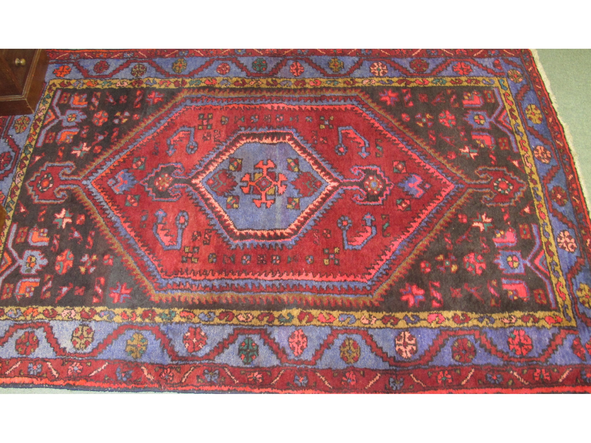 Appraisal: An Eastern floor rug on a red and blue ground