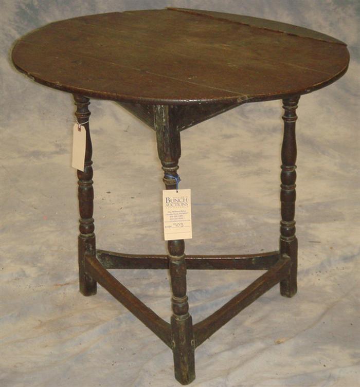 Appraisal: English oak triangular table with round top Plain stretcher base