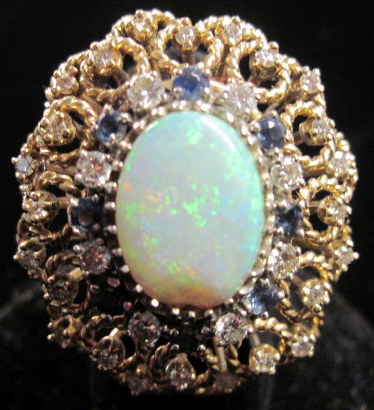 Appraisal: karat yellow gold sapphire and opal cocktail ring Oval opal