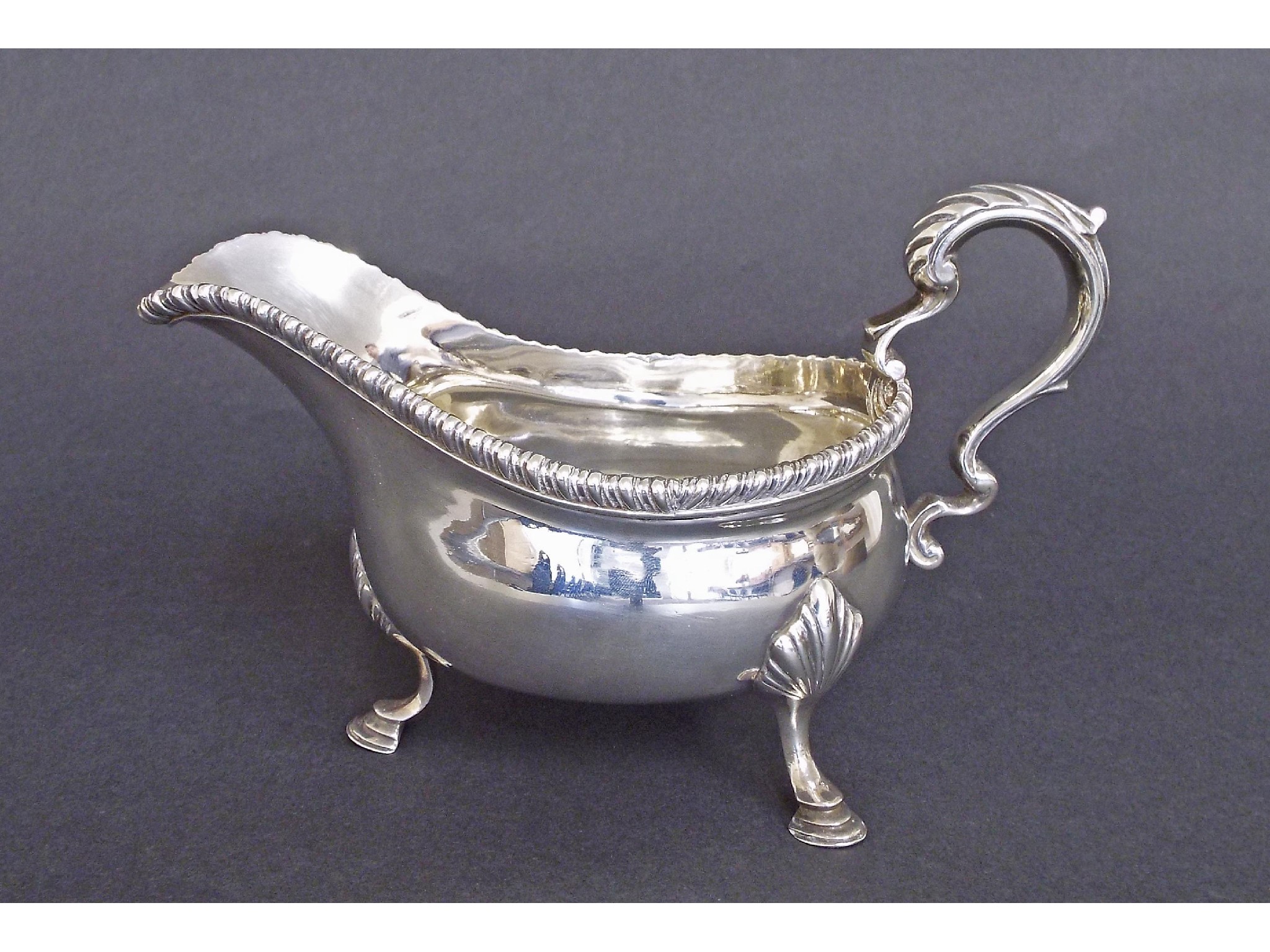 Appraisal: Georgian style silver sauce boat with gadrooned rim C-scroll handle