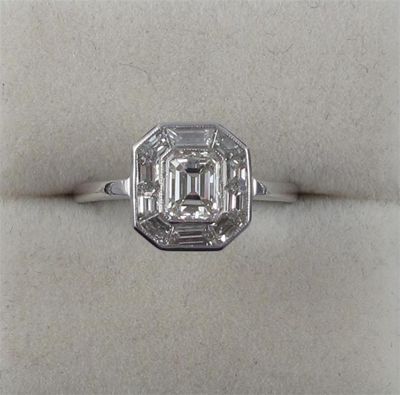 Appraisal: A diamond cluster ring Centered with an emerald cut diamond