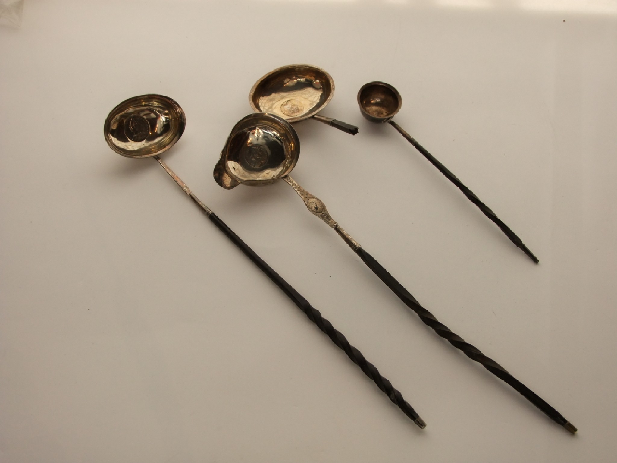 Appraisal: A miscellaneous collection of three Georgian silver toddy ladles various