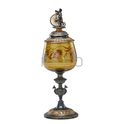 Appraisal: BOHEMIAN GLASS POKAL With a uniformed figure on a bicycle